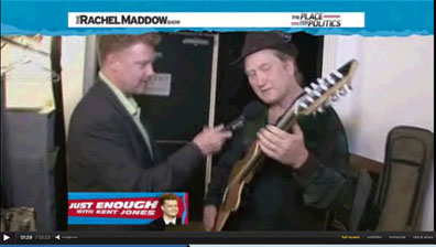 TV Screen Shot of Matthew Montfort Demonstrating the Glissentar on the Rachel Maddow Show